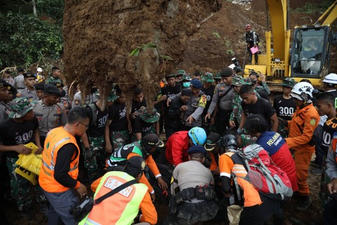 Deden (tengah) menangis saat petugas menemukan istri dan anaknya yang tertimbun longsor akibat gempa di Cugenang, Cianjur, Selasa (22/11/2022). Foto: Aditia Noviansyah/kumparan