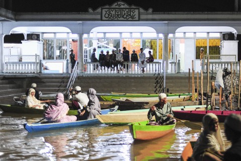 Umat muslim menggunakan perahu usai melaksanakan shalat Tarawih di Masjid Riyadhul Abidin, Ulu Gedong, Jambi, Jumat (15/3). Foto: ANTARA FOTO/Wahdi Septiawan