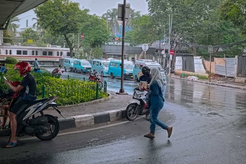 Jamilah (49), saat menjajakan jas hujannya di Jalan Raya Kalibata, Jakarta Selatan, Sabtu (16/3).  Foto: Fadhil Pramudya/kumparan