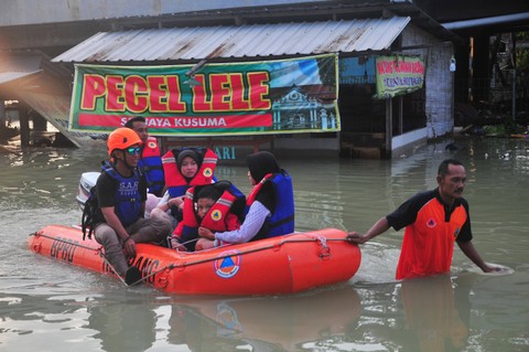 Relawan gabungan mengevakuasi warga korban banjir dengan perahu karet di Karanganyar, Demak, Jawa Tengah, Minggu (17/3/2024). Foto: Yusuf Nugroho/Antara Foto