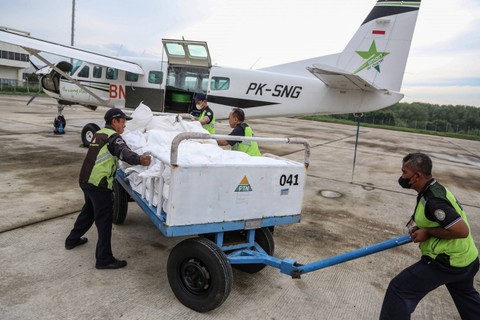 Petugas memasukkan garam ke dalam pesawat Cessna 208B Grand Caravan EX untuk persemaian garam dengan Teknologi Modifikasi Cuaca (TMC) di Bandara Internasional Ahmad Yani, Semarang, Jawa Tengah, Senin (18/3/2024). Foto: Makna Zaezar/Antara Foto