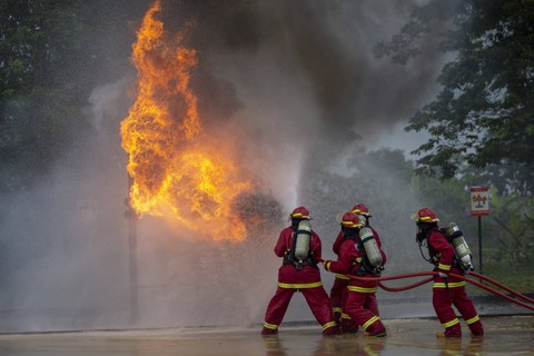 Peserta berusaha memadamkan api yang membakar saluran pipa saat lomba “fire combat” di Pertamina EP Jatibarang Field, Indramayu, Jawa Barat. Foto: Dedhez Anggara/Antara Foto