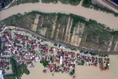 Foto udara permukiman warga terendam banjir di samping Sungai Wulan yang tanggulnya jebol di permukiman yang terendam banjir di Desa Ketanjung, Kecamatan Karanganyar, Kabupaten Demak, Jawa Tengah, Senin (18/3). Foto: ANTARA FOTO/Aji Styawan