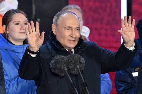 Presiden Rusia dan calon presiden Vladimir Putin berbicara kepada massa saat rapat umum dan konser merayakan 10 tahun aneksasi Rusia atas Krimea di Lapangan Merah di Moskow pada 18 Maret 2024. Foto: Natalia Kolesnikova / AFP
