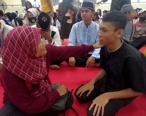 Fatimah saat bercengkerama dengan sang putra, Rian, yang menyandang cerebral palsy. Foto: Masruroh/Basra