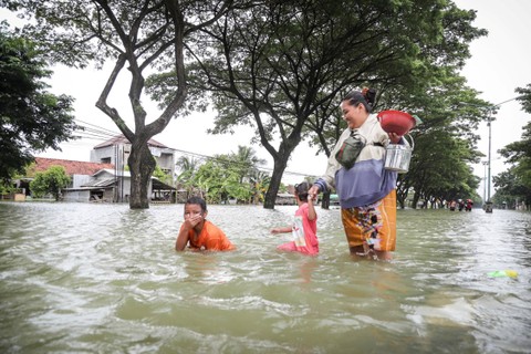 Warga melintasi banjir yang merendam Jalur Pantura Demak-Kudus di Karanganyar, Demak, Jawa Tengah, Kamis (21/3/2024). Foto: Dicky Adam Sidiq/kumparan