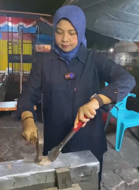 Kepala Disporapar Kalbar, Windy Prihastari tak canggung saat membakar dan menyajikan Sotong Pangkong. Foto: Dok. Adpim Pemprov Kalbar.