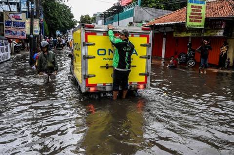Warga menaiki mobil bak untuk melewati banjir di kawasan Joglo, Jakarta, Jumat (22/3/2024). Foto: Rivan Awal Lingga/ANTARA FOTO