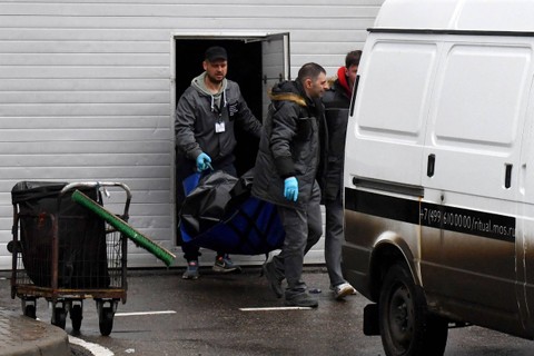 Petugas penegak hukum membawa jenazah korban serangan senjata, untuk dimasukkan ke dalam mobil jenazah di Balai Kota Crocus di Krasnogorsk, di luar Moskow, Sabtu (23/3/2024) Foto: Olga Maltseva / AFP