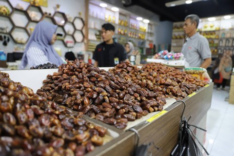 Pedagang melayani pembeli buah kurma di salah satu toko kurma kawasan Pasar Tanah Abang, Jakarta, Minggu, (24/3/2024). Foto: Iqbal Firdaus/kumparan