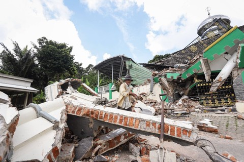 Warga melintas di dekat Masjid Jamik Al Muhajirin yang sebagian bangunannya roboh akibat gempa di Dusun Balikbakgunung, Sangkapura, Pulau Bawean, Gresik, Jawa Timur, Minggu (24/3/2024). Foto: Rizal Hanafi/ANTARA FOTO