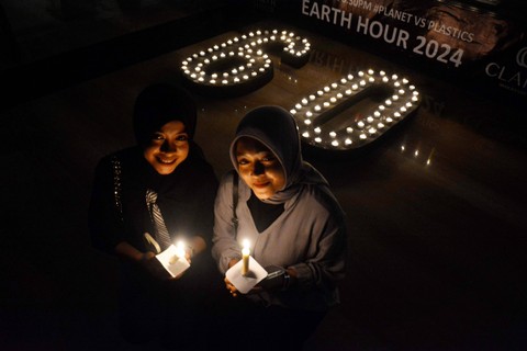 Aktivis pemerhati lingkungan menyalakan lilin saat Peringatan Earth Hour di Hotel Claro, Makassar, Sulawesi Selatan, Sabtu (23/3/2024). Foto: Hasrul Said/ANTARA FOTO