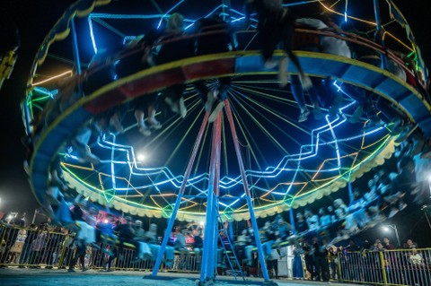 Pengunjung menikmati wahana permainan di Pasar Malam Lentora di Palu, Sulawesi Tengah, Minggu (24/3/2024). Foto: ANTARA FOTO/Basri Marzuki