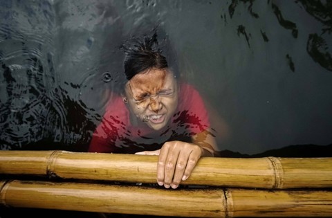 Seorang anak berenang di Kali Cilemahabang, Cikarang Utara yang tercemar limbah Industri. Foto: Iqbal Firdaus/kumparan