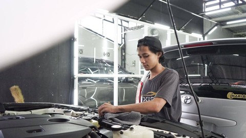 Seorang pekerja sedang memoles mobil pelanggan. Foto: Arif UT/Pandangan Jogja