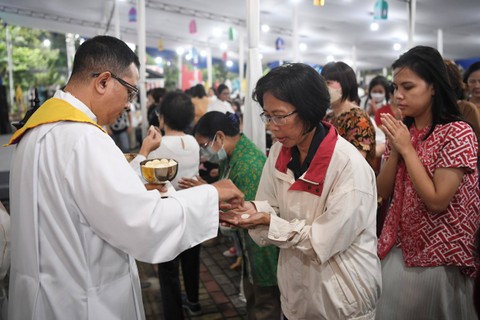 Prodiakon memberikan komuni berupa hosti kepada umat katolik saat ibadah Misa Kamis Putih di Gereja Katedral, Jakarta, Kamis (28/3/2024). Foto: M Risyal Hidayat/ANTARA FOTO