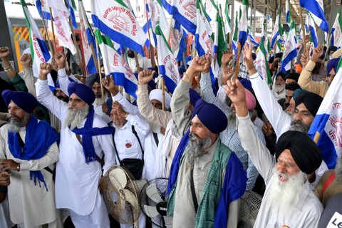 Para petani meneriakkan slogan-slogan saat protes menuntut harga minimum hasil panen, sebelum berangkat ke perbatasan negara bagian Haryana-Punjab di Shambhu, dari stasiun kereta api di Amritsar, Sabtu (31/3/2024). Foto: NARINDER NANU/AFP