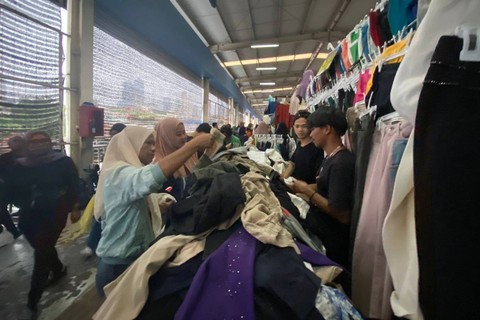 Penjual melayani pembeli pakaian di Skybridge Pasar Tanah Abang, Jakarta, Minggu (31/3/2024). Foto: Ainun Nabila/kumparan