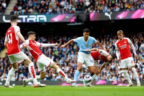 Pemain Manchester City  Rodri berebut bola dengan pemain Arsenal Jorginho pada pertandingan lanjutan Liga Inggris di Stadion Etihad, Manchester, Inggris, Minggu (31/3/2024). Foto: Carl Recine/REUTERS