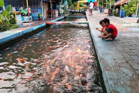 Pengunjung bermain di kawasan Bendhung Lepen, Kampung Mrican, Kelurahan Giwangan, Kemantren Umbulharjo, Kota Yogyakarta, Senin (1/4/2024). Foto: Arfiansyah Panji Purnandaru/kumparan