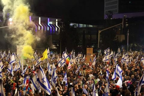Demonstran anti-pemerintah Israel mengibarkan bendera selama protes menuntut pembebasan sandera yang ditahan oleh gerakan Hamas Palestina di Jalur Gaza sejak serangan 7 Oktober, di Yerusalem, (31/3/2024). Foto: AHMAD GHARABLI / AFP