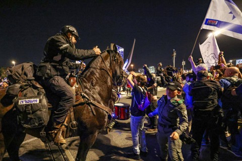 Polisi yang berjaga di Israel membubarkan demonstran anti-pemerintah yang memblokir jalan selama protes menuntut pembebasan sandera yang ditahan oleh gerakan Hamas Palestina di Jalur Gaza sejak serangan 7 Oktober, di Yerusalem, (31/3/2024) Foto: AHMAD GHARABLI / AFP