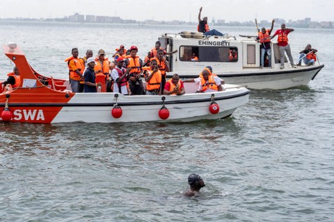Pendukung Akinrodoye Samuel bersorak, saat dia berenang untuk menyelesaikan upaya ambisiusnya berenang di Jembatan Daratan Ketiga sepanjang 11,8 km, menganjurkan tema 'Berenang Melawan Bunuh Diri Dan Depresi' di Lagos, Nigeria, (30/3/2024). Foto: Marvellous Durowaiye / Reuters