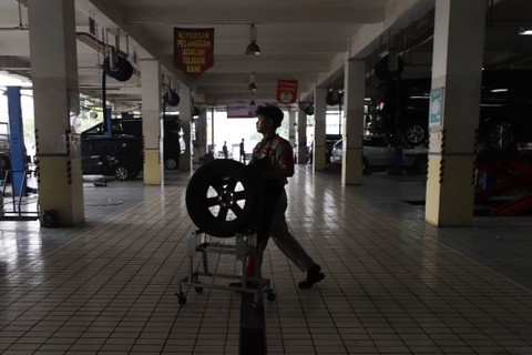 Montir mengangkat ban mobil di bengkel Auto2000 Permata Hijau, Kebayoran Lama, Jakarta Selatan, Selasa (2/4/2024). Foto: Jamal Ramadhan/kumparan