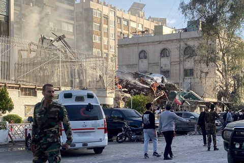 Orang-orang berkumpul di dekat lokasi yang rusak setelah serangan udara Israel terhadap kedutaan Iran di Damaskus, Suriah, pada Senin (1/4/2024). Foto: Firas Makdesi/REUTERS