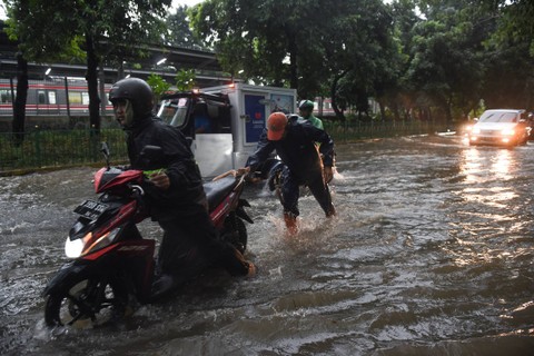 Petugas PPSU membantu mendorong pengendara motor yang mogok akibat genangan banjir di Jalan Lenteng Agung Raya, Jakarta, Rabu (3/4/2024). Foto: Indrianto Eko Suwarso/ANTARA FOTO