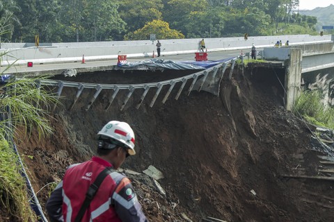 Petugas melintas di sekitar jalan tol yang amblas di ruas tol Bocimi KM 64, Sukabumi, Jawa Barat, Kamis (4/4/2024).  Foto: ANTARA FOTO/Henry Purba