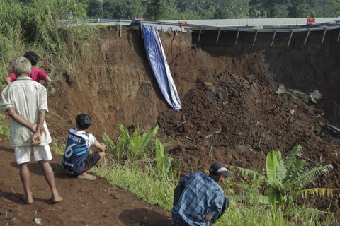 Petugas melintas di sekitar jalan tol yang amblas di ruas tol Bocimi KM 64, Sukabumi, Jawa Barat, Kamis (4/4/2024).  Foto: ANTARA FOTO/Henry Purba
