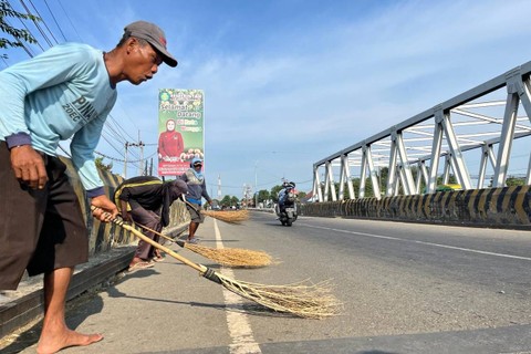 Warga penyapu koin saat menunggu dan berebut koin di tengah jalan Pantura saat mudik Lebaran 2024, Jumat (5/4/2024). Foto: Panji Asmara/kumparan