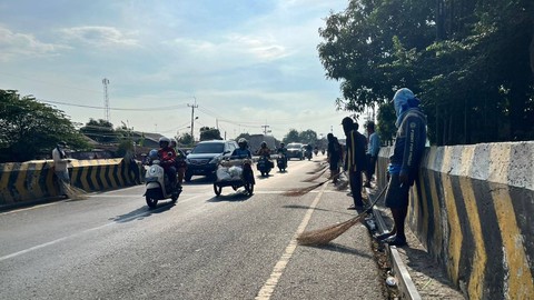 Warga penyapu koin saat menunggu dan berebut koin di tengah jalan Pantura saat mudik Lebaran 2024, Jumat (5/4/2024). Foto: Panji Asmara/kumparan