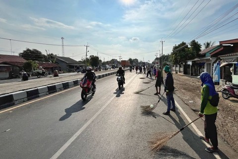 Warga penyapu koin saat menunggu dan berebut koin di tengah jalan Pantura saat mudik Lebaran 2024, Jumat (5/4/2024). Foto: Panji Asmara/kumparan