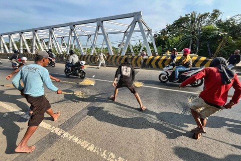 Warga penyapu koin saat menunggu dan berebut koin di tengah jalan Pantura saat mudik Lebaran 2024, Jumat (5/4/2024). Foto: Panji Asmara/kumparan