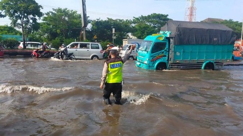 Polantas mengatur arus lalulintas di kawasan Genuk yang terendam banjir pada Sabtu (6/4/2024). Foto: Dok. humas.polri