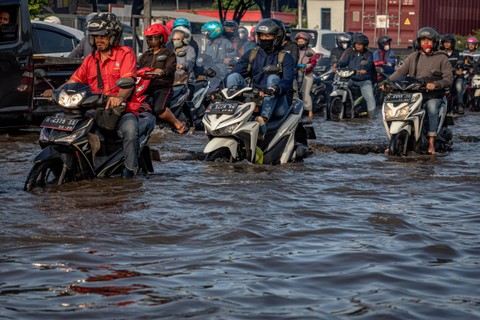 Pengendara sepeda motor menembus banjir yang menggenangi jalur utama pantura Semarang-Surabaya di Jalan Kaligawe Raya, Kota Semarang, Jawa Tengah, Sabtu (6/4/2024). Foto: Aji Styawan/ANTARA FOTO 