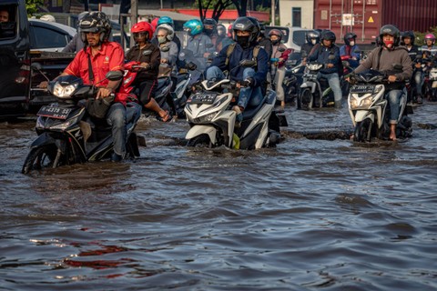 Pengendara sepeda motor menembus banjir yang menggenangi jalur utama pantura Semarang-Surabaya di Jalan Kaligawe Raya, Kota Semarang, Jawa Tengah, Sabtu (6/4/2024). Foto: Aji Styawan/ANTARA FOTO
