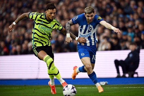 Pemain Arsenal Ben White beraksi dengan Julio Enciso dari Brighton & Hove Albion di The American Express Community Stadium, Brighton, Inggris, Sabtu (6/4/2024). Foto: Dylan Martinez/Reuters