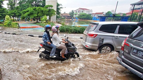Pengendara motor yang menerobos banjir saat genangan air terjadi akibat hujan deras melanda Kota Palembang sejak pagi, Minggu (7/4) Foto: ary priyanto/urban id