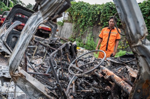 Seorang petugas melihat bangkai kendaraan pascakecelakaan di Tol Jakarta-Cikampek KM 58 di Pool Derek Cikopo, Purwakarta, Jawa Barat, Senin (8/4/2024). Foto: Bayu Pratama S/ANTARA FOTO