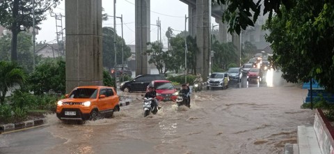 Para pengendara saat menerobos banjir di depan gerbang SMKN2 Palembang, Foto : Abdul Toriq/Urban Id