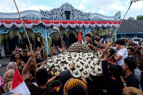 Warga dan Abdi Dalem berebut gunungan saat perayaan Tradisi Grebeg Syawal di halaman Keraton Kasunanan Surakarta Hadiningrat Solo, Jawa Tengah, Kamis (11/4/2024). Foto: Maulana Surya/Antara Foto