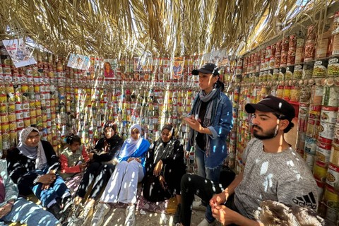 Warga Palestina duduk di dalam tenda yang terbuat dari wadah makanan kaleng untuk menggambarkan situasi warga Palestina di tengah konflik Israel dan Hamas, di Deir Al-Balah di Jalur Gaza tengah, pada 6 April 2024. Foto: Doaa Rouqa/Reuters