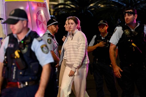 Masyarakat dikawal oleh petugas polisi NSW dari dalam Westfield Bondi Junction setelah beberapa orang ditikam di dalam pusat perbelanjaan pinggiran timur di Sydney, Australia, Sabtu (13/4/2024). Foto: AAP Image/Bianca De Marchi via REUTERS