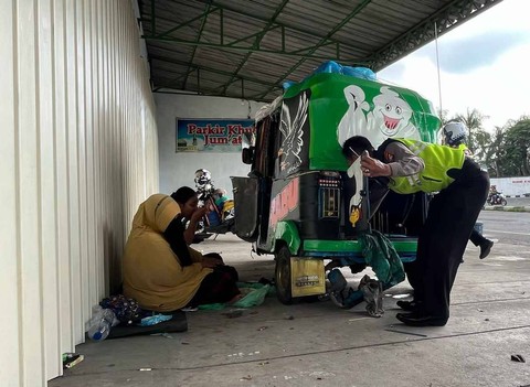 Anggota Polres Mojokerto melakukan pertolongan pertama terhadap kendaraan bajaj pemudik Jakarta-Banyuwangi yang mogok di Trowulan.  Foto: Nana/mili.id