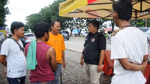 Sejumlah sopir truk yang tertahan di terminal AAL sedang berkomunikasi dengan petugas jaga memastikan izin melintas, Minggu (14/4) Foto: ary priyanto/urban id