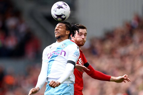 Pemain Liverpool Andrew Robertson berebut bola dengan pemain Crystal Palace Michael Olise pada pertandingan lanjutan Liga Inggris di Anfield, Liverpool, Inggris, Minggu (14/4/2024). Foto: Carl Recine/REUTERS