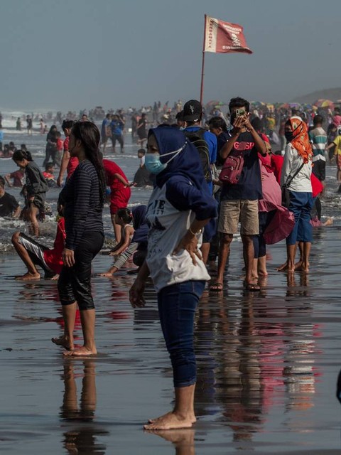 Wisatawan bermain air di Pantai Parangtritis, Bantul, DI Yogyakarta, Minggu (16/5/2021). Foto: Hendra Nurdiyansyah/Antara Foto